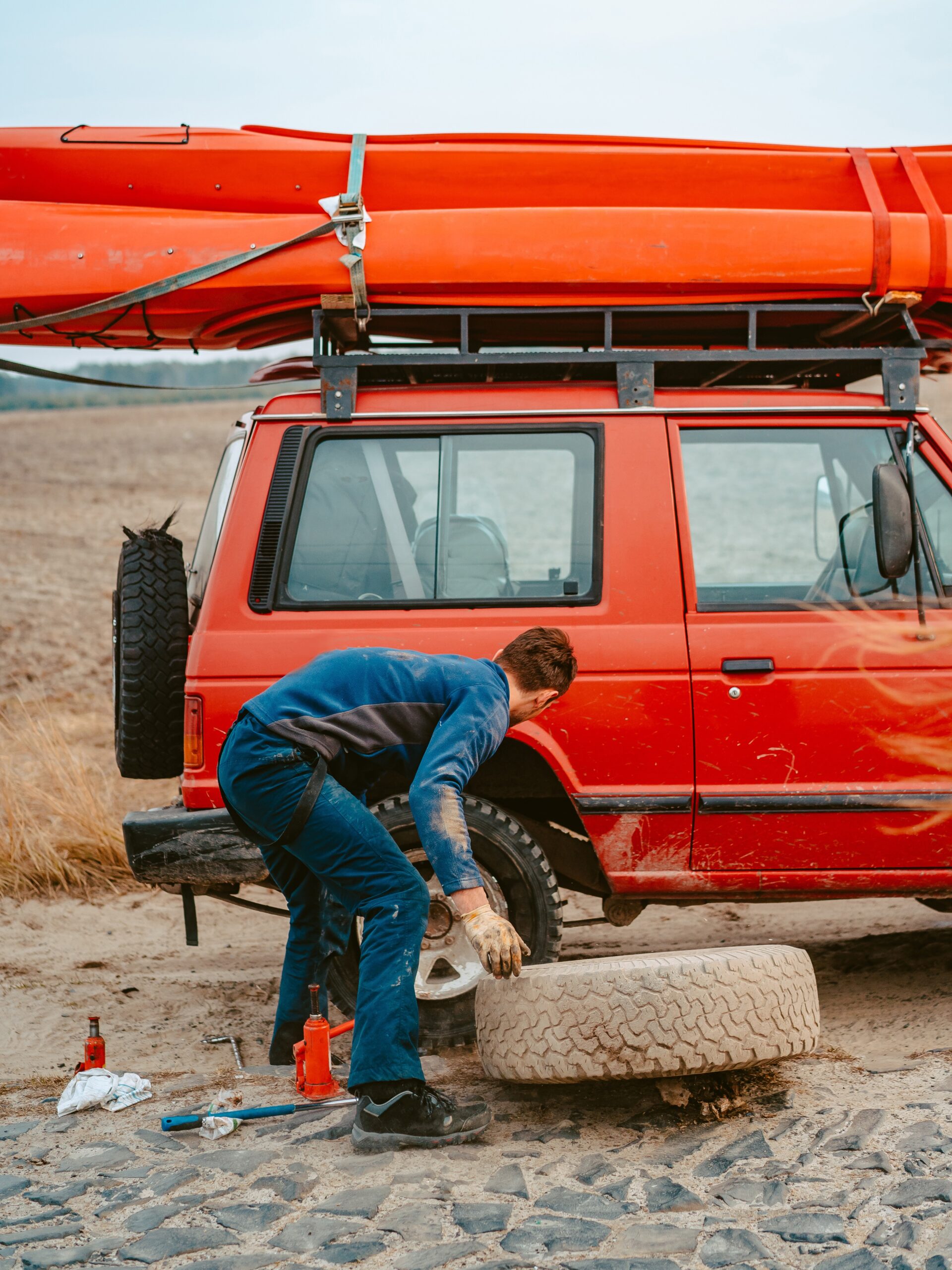 Man change the wheel manually on a 4x4 off road truck on the road